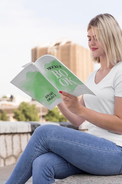 PSD femme lisant un livre sur la rue