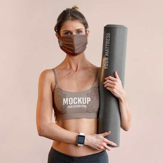 PSD femme avec masque facial tenant un tapis de yoga