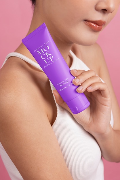 Femme montrant de la crème pour le soin de la peau et la beauté