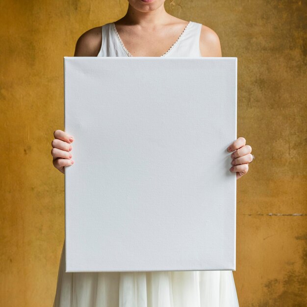 Femme montrant une maquette de toile vierge