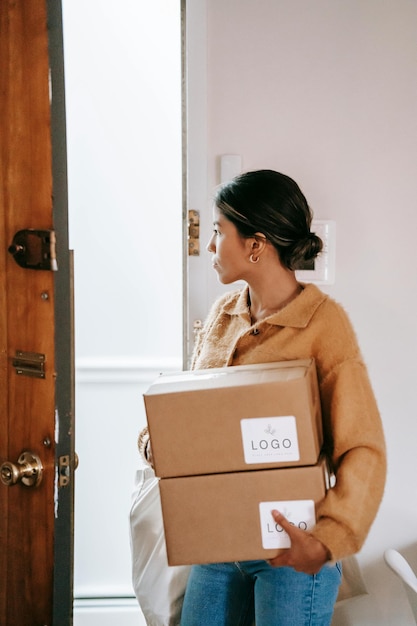 une femme portant des boîtes qui disent 100 sur le devant d'une porte