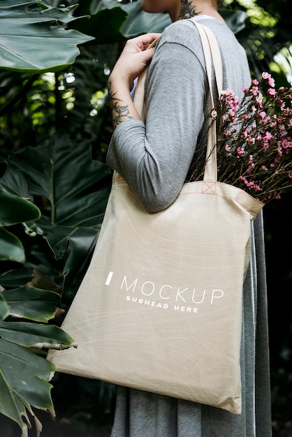 Femme portant une maquette de sac fourre-tout avec des fleurs