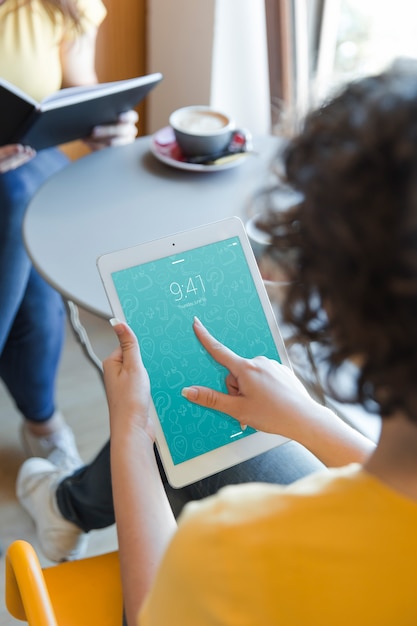 PSD femme avec tablette dans la bibliothèque