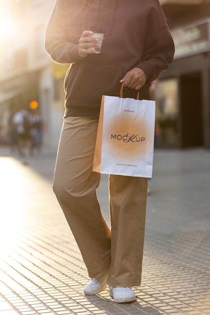 Femme tenant un sac à provisions à l'extérieur dans la rue