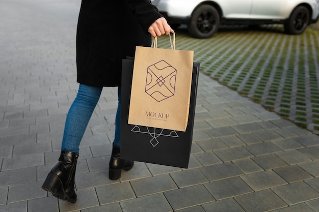 Femme tenant un sac à provisions luxueux à l'extérieur