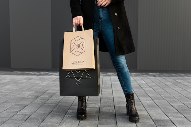 Femme tenant un sac à provisions luxueux à l'extérieur