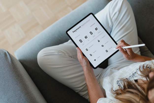 Femme utilisant un stylet avec une tablette numérique pendant la quarantaine du coronavirus à la maison