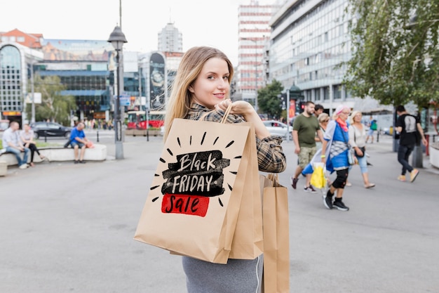 Femme en ville avec des sacs de vendredi noir