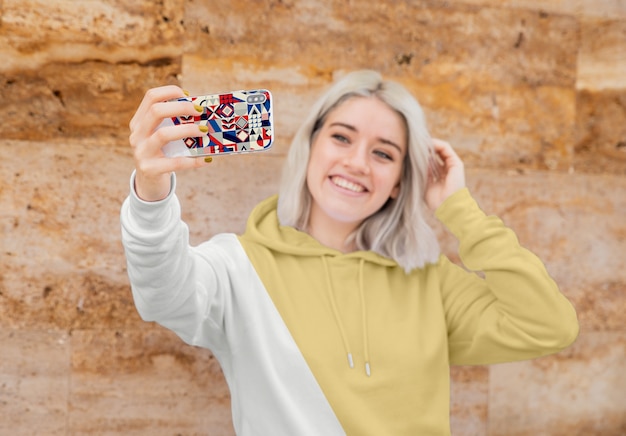 Fille avec capuche prenant selfie