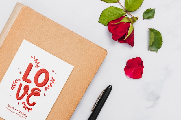 Flache buchlage mit rose und stift