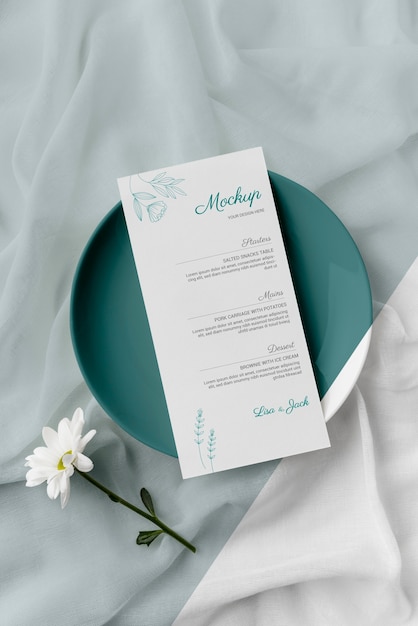 flat lay of table arrangement with spring menu mock-up on plate and flower
