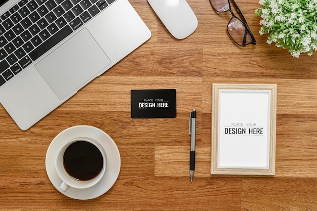 Flat lay Vista superior Moldura vertical em branco Mockup e cartão preto na mesa de escritório computador laptop mouse óculos xícara de café e planta Espaço vazio para inserir seu design