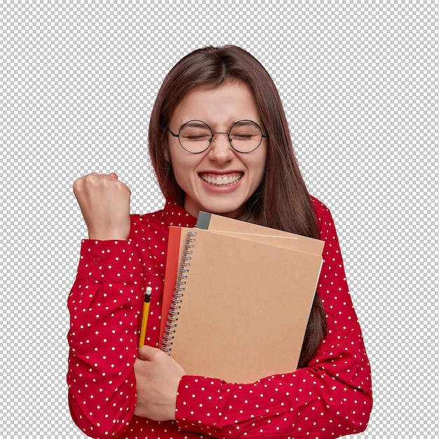 Foto de uma senhora caucasiana cheia de alegria apertando o punho tem um grande sorriso segura o caderno lápis aplausos como tem sucesso