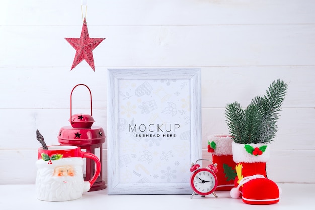 PSD foto trocista com moldura branca, lanterna vermelha e copo de papai noel em fundo branco de madeira