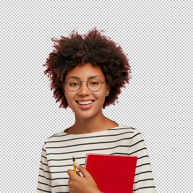 Fotografía de estudio de una chica bonita de piel oscura con una sonrisa suave se prepara para las clases lleva una libreta roja y un lápiz