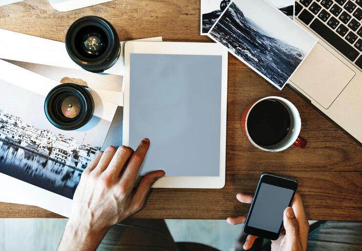 PSD fotografo che usa un telefono con schermo vuoto e un tablet digitale
