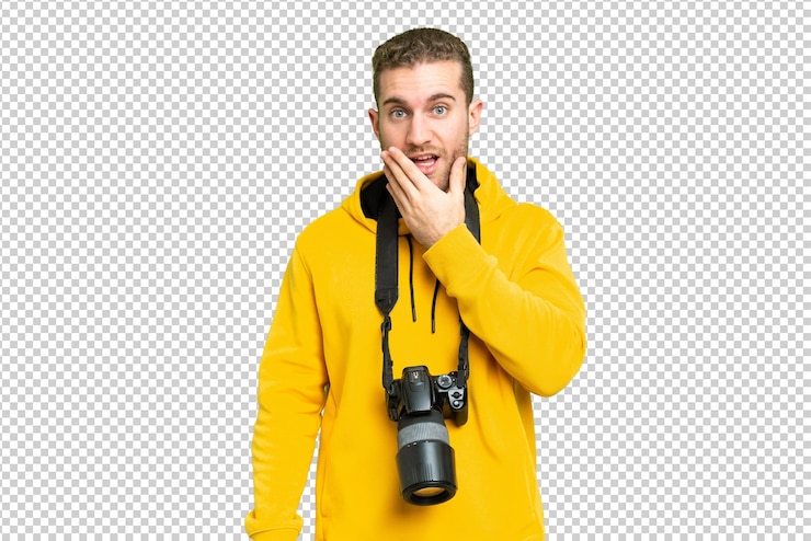 PSD el fotógrafo más joven sobre el fondo de la clave de croma aislado sorprendido y conmocionado mientras miraba a la derecha