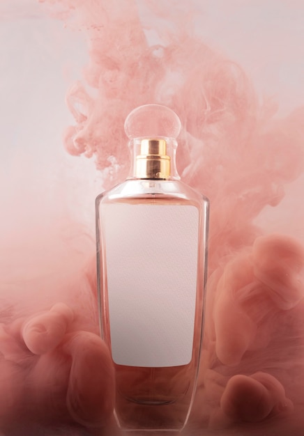 Frasco de perfume y humo rosa.