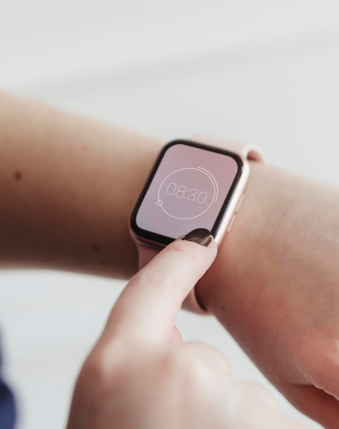 Frau, die auf ihrem digitalen Smartwatch-Modell auf die Uhrzeit schaut