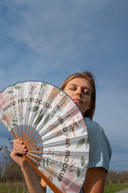 Frau, die handventilator mit mock-up-design hält