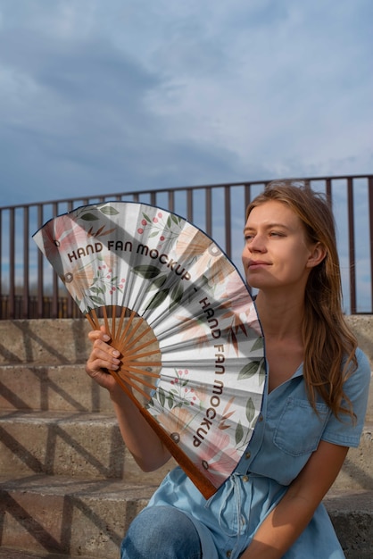 PSD frau, die handventilator mit mock-up-design hält