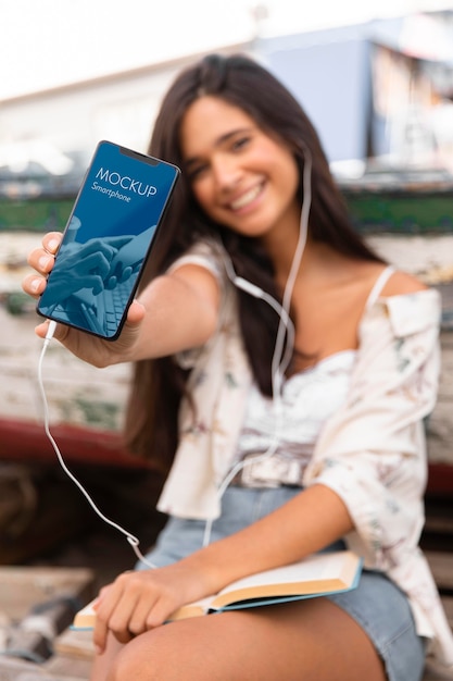 Frau, die Smartphone hält und Musik auf Kopfhörern hört