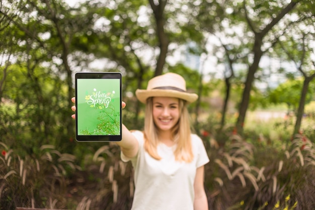 Frau, die Tablettenmodell in der Natur darstellt