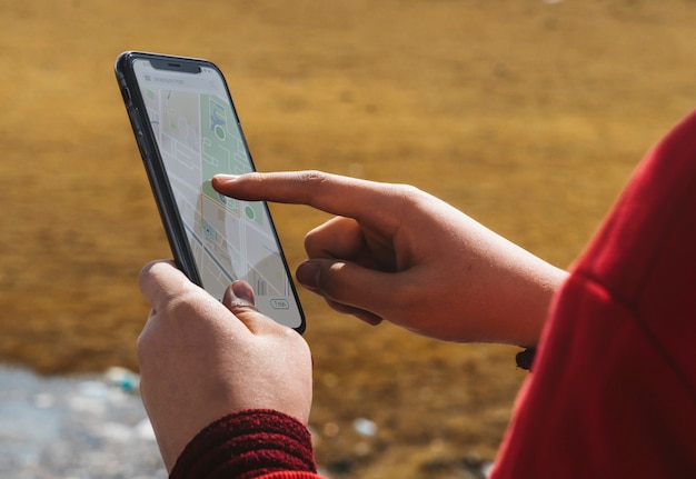 Frau draußen unter Verwendung einer Smartphonekartenanwendung