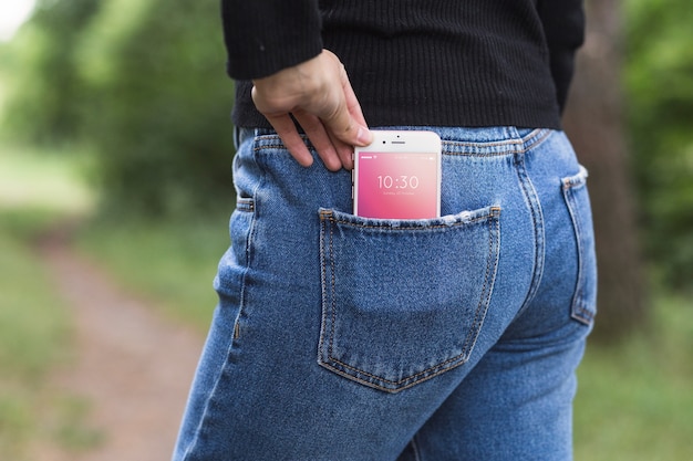 PSD frau in der natur mit smartphone in der tasche