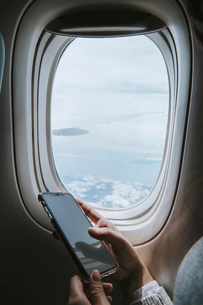 Frau mit Smartphone im Flugzeug