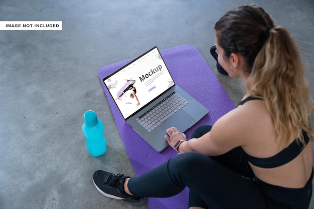 PSD frau übt fitnessstudio auf yogamatte mit laptopmodell