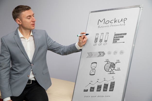 Geschäftsperson, die sich in einer Besprechung auf einem großen Whiteboard-Modell vorstellt