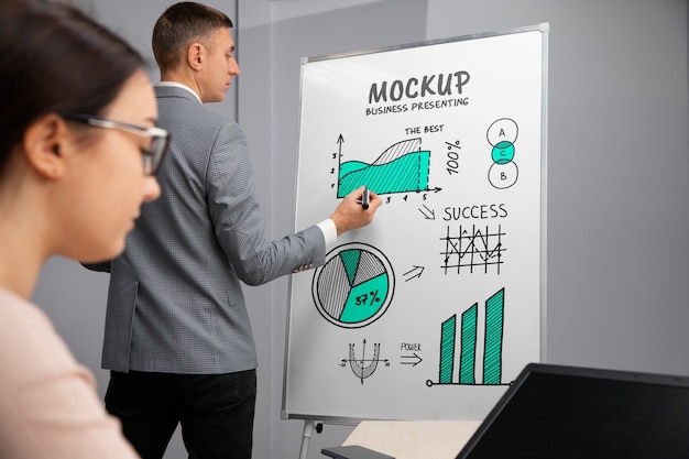 Geschäftsperson, die sich in einer Besprechung auf einem großen Whiteboard-Modell vorstellt
