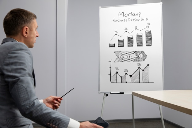 Geschäftsperson, die sich in einer Besprechung auf einem großen Whiteboard-Modell vorstellt
