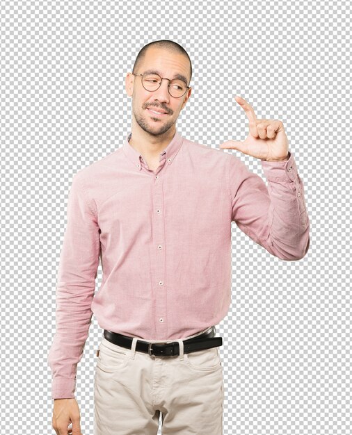 Giovane che fa un gesto di piccola taglia con la mano