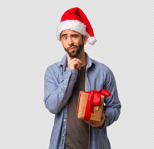 Giovane che porta il cappello della Santa che dubita e confuso