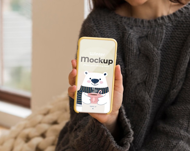 Giovane donna che tiene un telefono mock-up