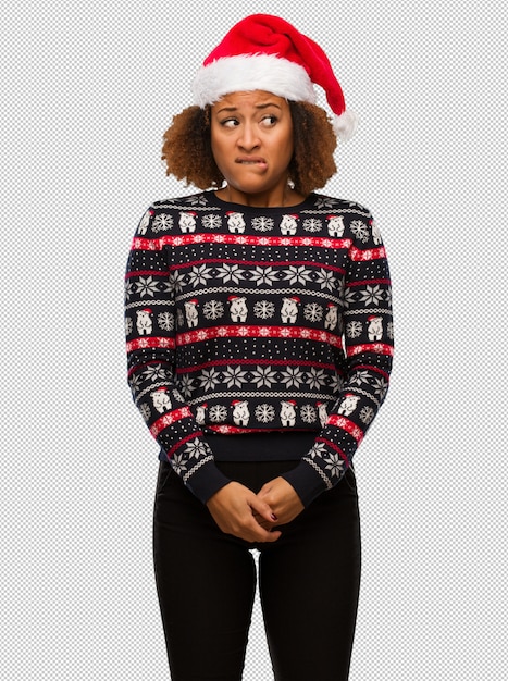 Giovane donna di colore in un maglione di Natale alla moda con stampa pensando a un&#39;idea