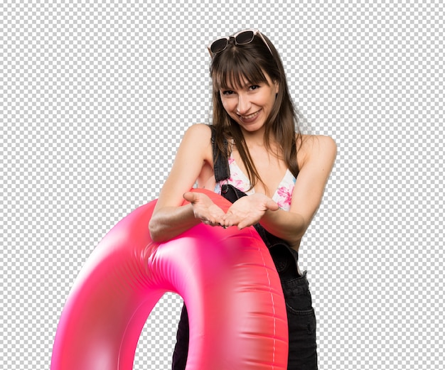 Giovane donna in bikini che tiene copyspace immaginario sul palmo per inserire un annuncio