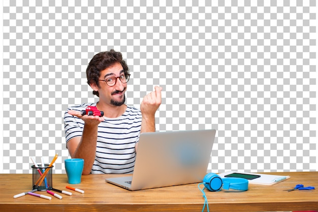 Giovane grafico pazzo su una scrivania con un computer portatile e con un modello di auto rossa