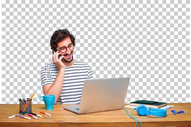 Giovane grafico pazzo su una scrivania con un computer portatile e con un telefono touch screen intelligente