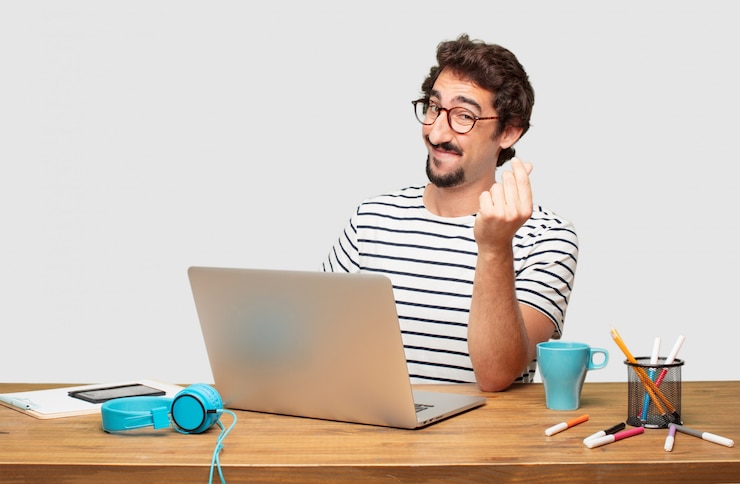 PSD giovane graphic designer con la barba con un laptop che sembra felice, orgoglioso e soddisfatto