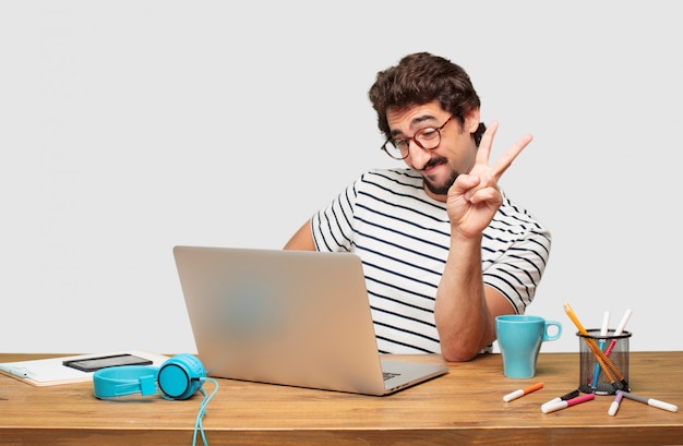 giovane graphic designer con la barba con un laptop con un&#39;espressione orgogliosa, felice e sicura