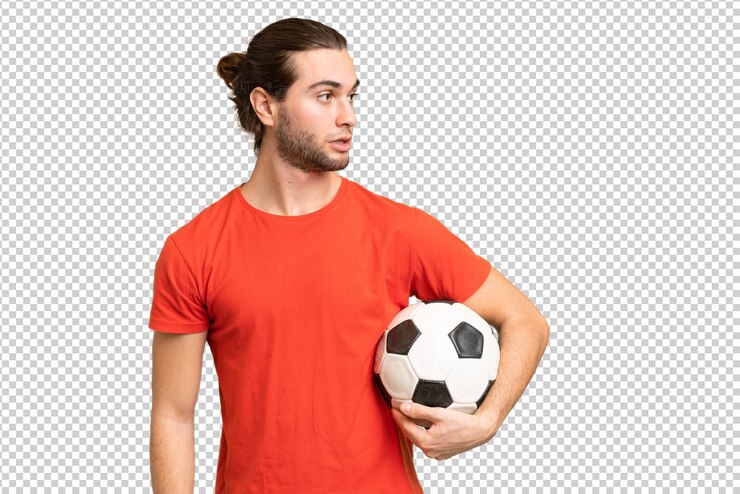 PSD giovane uomo bello isolato su sfondo verde croma con pallone da calcio