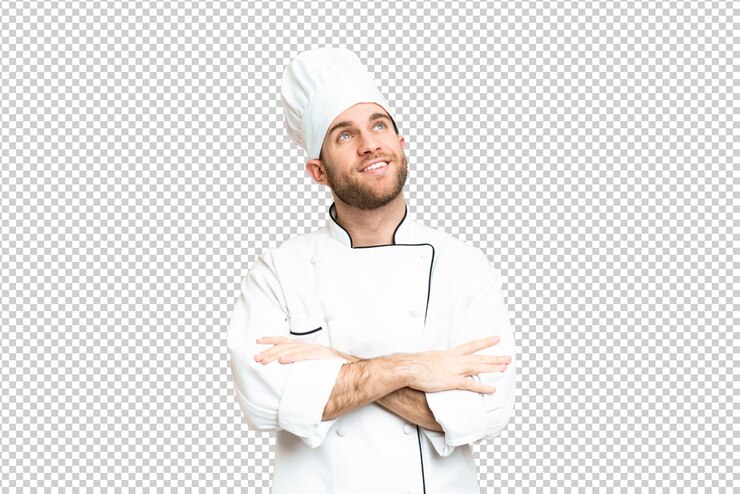 PSD giovane uomo biondo chef su sfondo chiave croma isolato guardando in alto mentre sorride