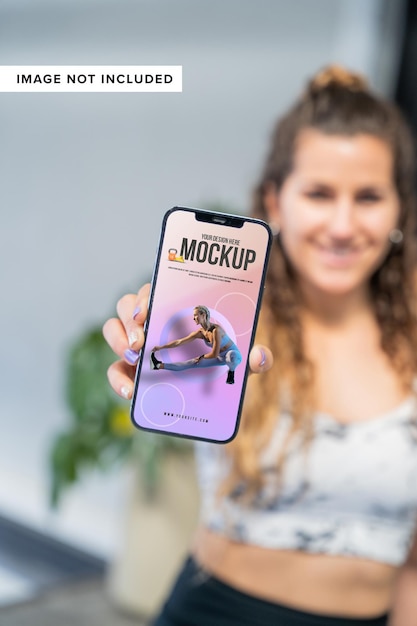 Glückliches sportliches Mädchen, das Handymodell präsentiert