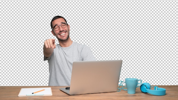 Gracioso joven sentado en su escritorio