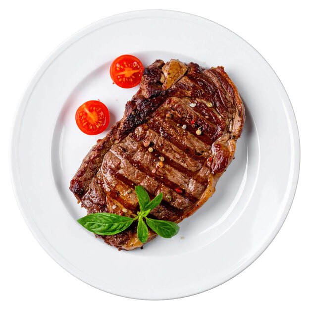 Grilled steak with fresh herbs and tomatoes on plate