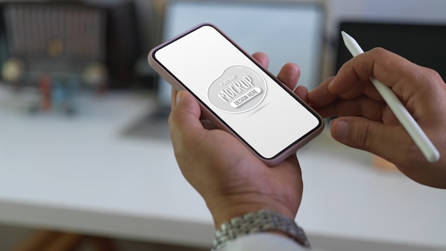 Gros plan sur les mains tenant la maquette de l'écran du smartphone