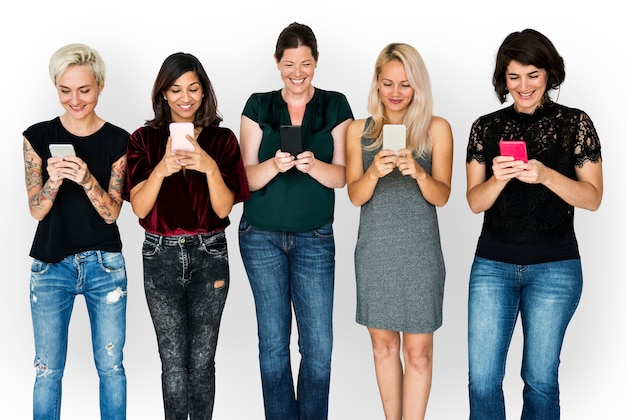 Groupe de bonheur de copines souriant et conneted par téléphone mobile